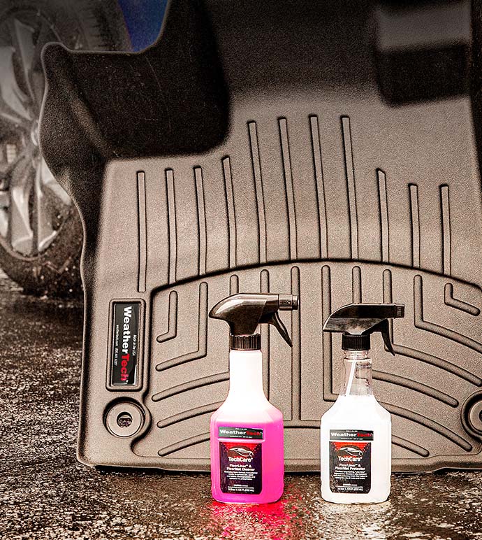 techcare auto cleaning bottles standing next to a Floorliner floor mat